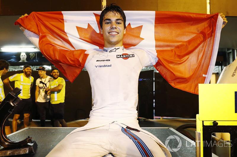 Lance Stroll, Williams FW40, celebrates third place by displaying a Canadian flag in the pit lane