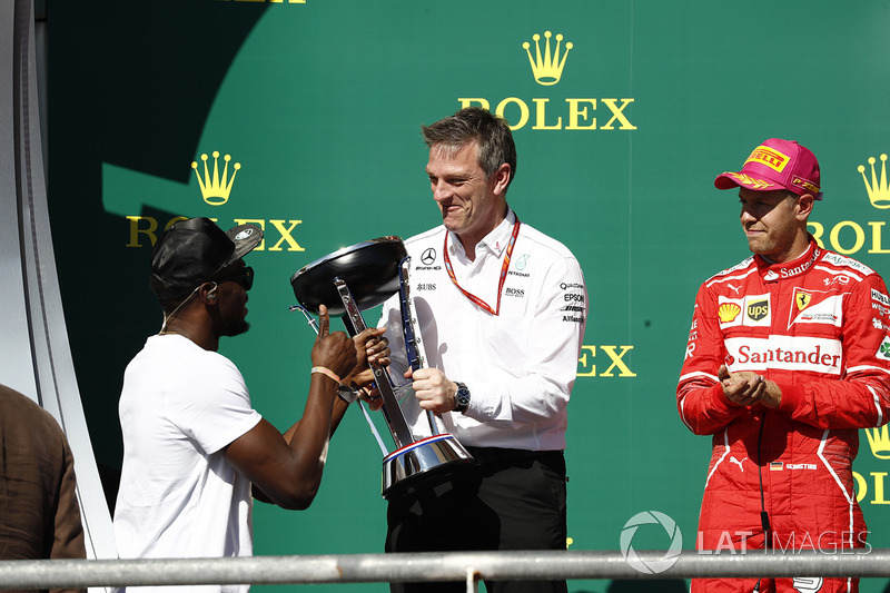 Usain Bolt entrega a James Allison, director técnico de Mercedes AMG F1, el trofeo de constructores