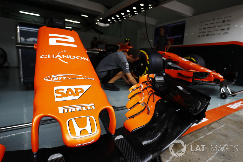 A McLaren nose cone, while a mechanic works on the Stoffel Vandoorne McLaren MCL32.