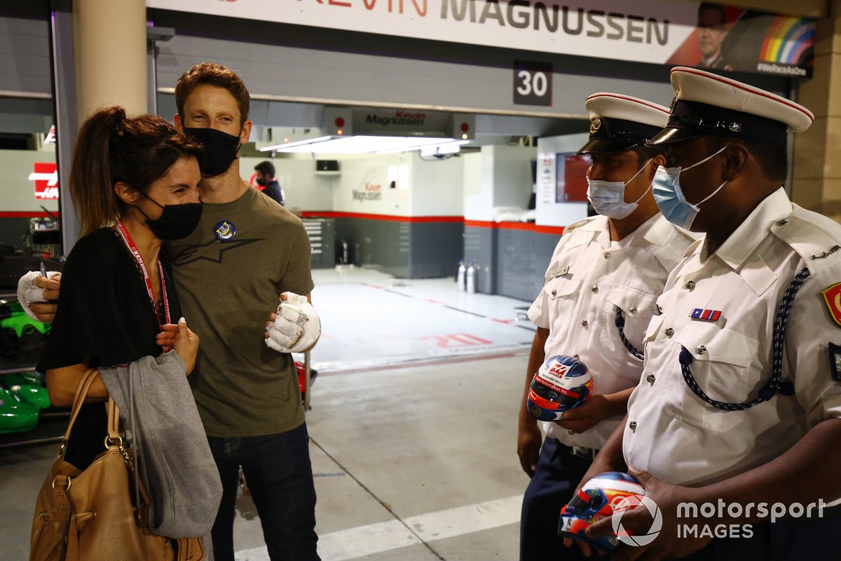 Ромен Грожан, Haas F1, и его жена Марион с судьями Гран При Бахрейна, которые помогали тушить машину гонщика после аварии