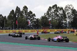 Marshals wave drivers, including Esteban Ocon, Force India VJM11 and Esteban Ocon, Force India VJM11, around debris from an opening lap accident
