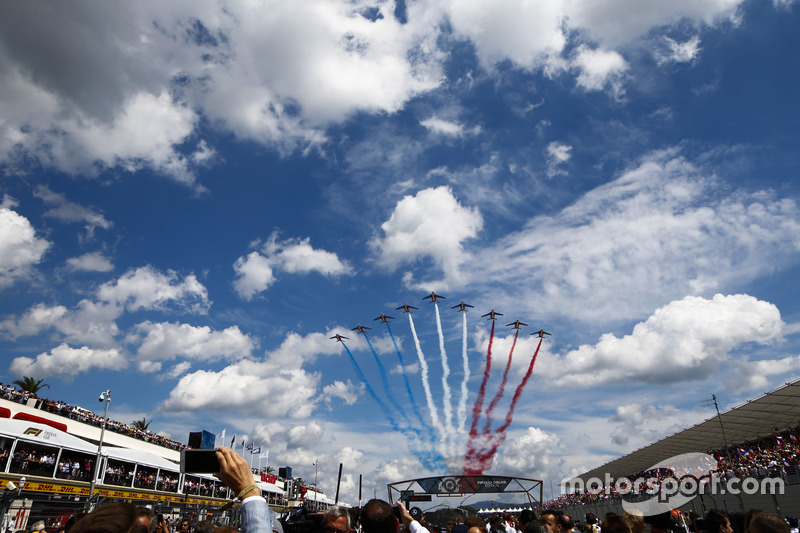 The French Air Force Aerobatics team, La Patrouille de France, overfly the grid in their Dassault Alpha Jet Es