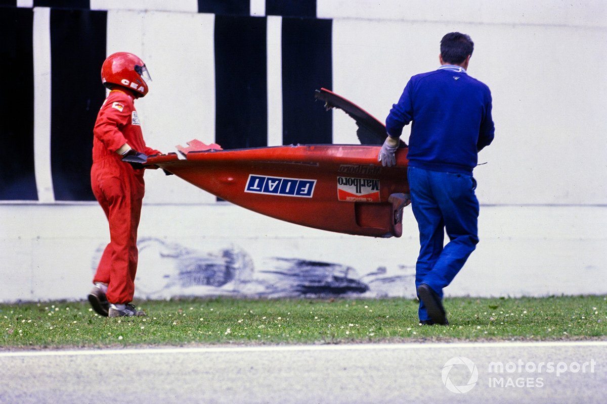 Les commissaires nettoient les débris de l'accident de Gerhard Berger