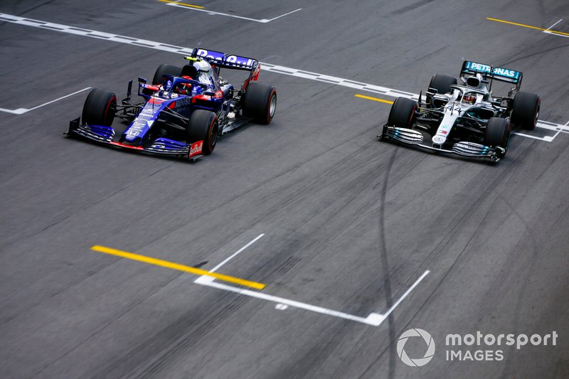 Pierre Gasly, Toro Rosso STR14 crosses the finish line followed by Lewis Hamilton, Mercedes AMG F1 W10