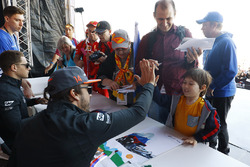 Fernando Alonso, McLaren, dar una palmadita a un joven fan, Stoffel Vandoorne, McLaren, firma autógrafos