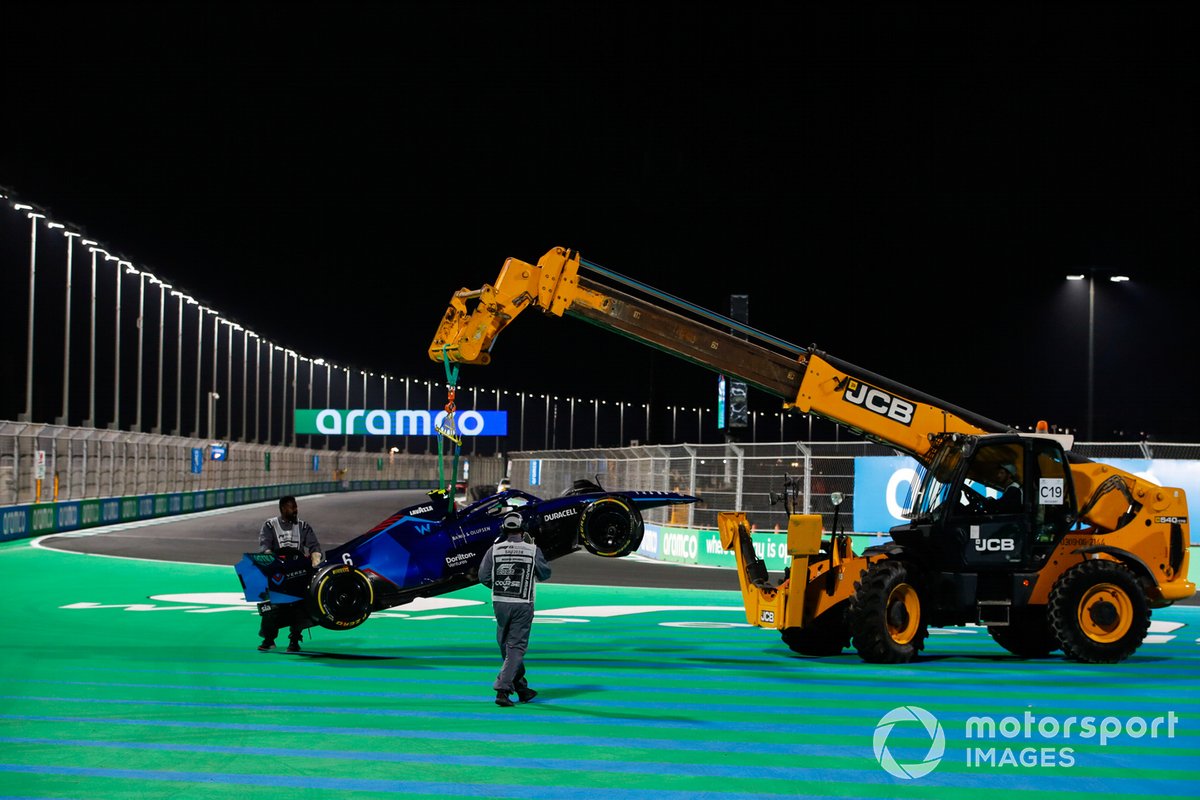 Marshals verwijderen de beschadigde auto van Nicholas Latifi, Williams FW44, van het circuit