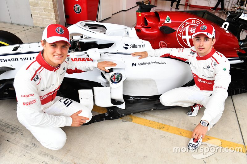 Marcus Ericsson en Charles Leclerc flankeren het logo van Additive Industries op de Sauber Alfa Romeo F1-wagen