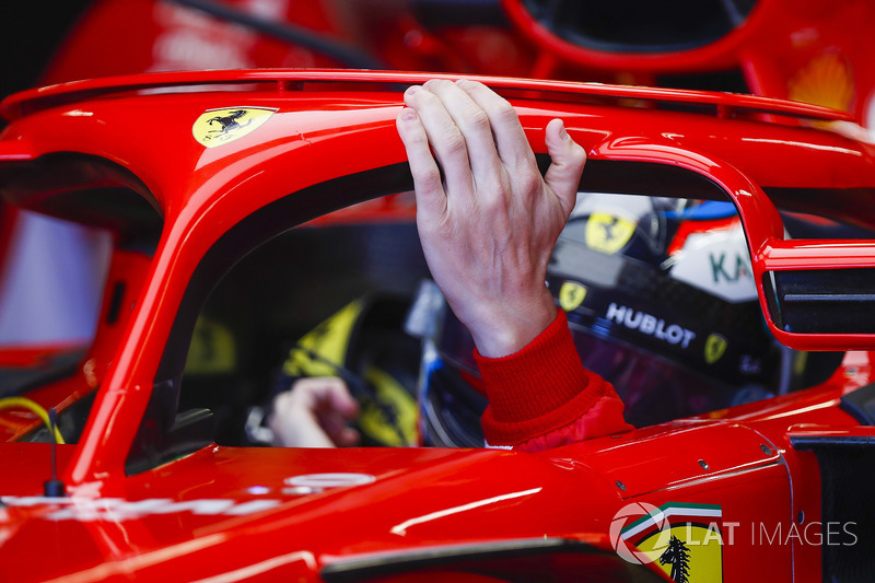 Kimi Raikkonen, Ferrari, rests a hand on his halo