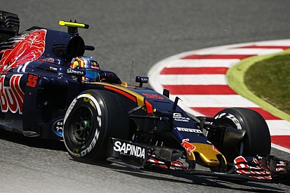 Sainz és a jelenet, amikor a zászlóval a kezében ünnepel az F1-es gép volánja mögött