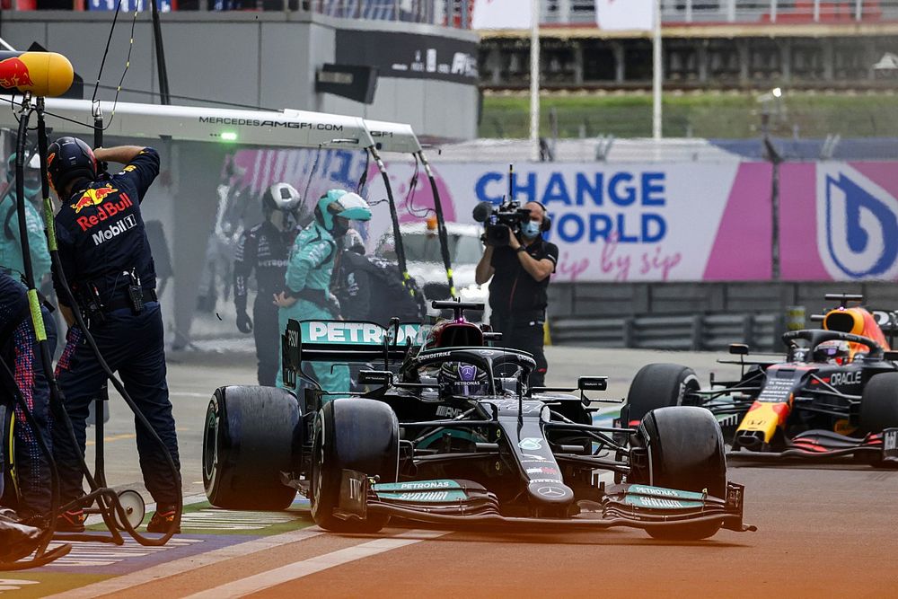Lewis Hamilton, Mercedes W12, leaves his pit box as Max Verstappen, Red Bull Racing RB16B, comes in for a stop