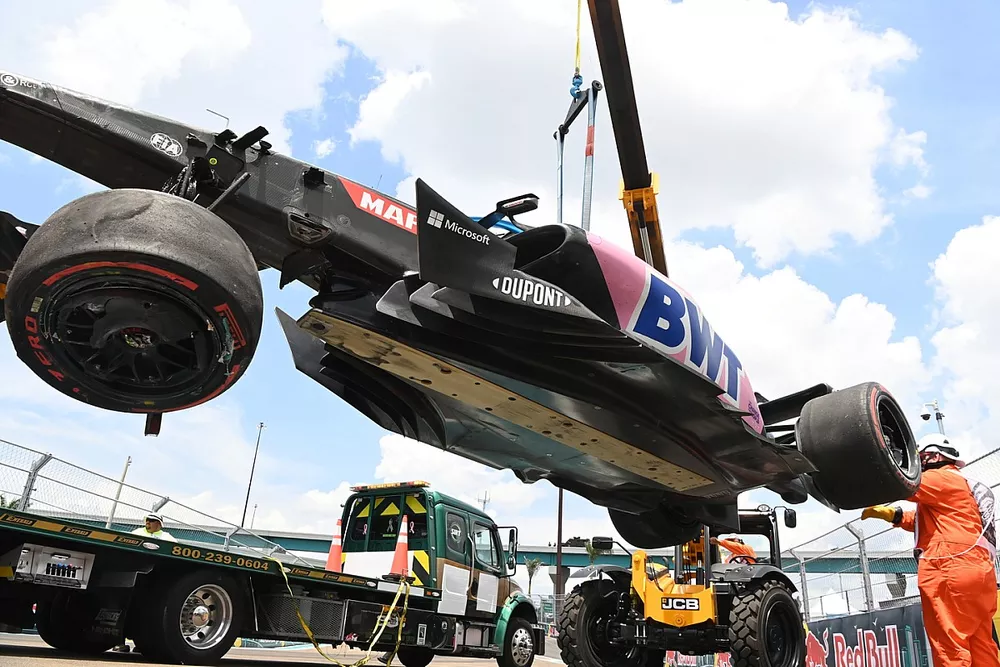 Marshals move the car of Esteban Ocon, Alpine A522, after his crash