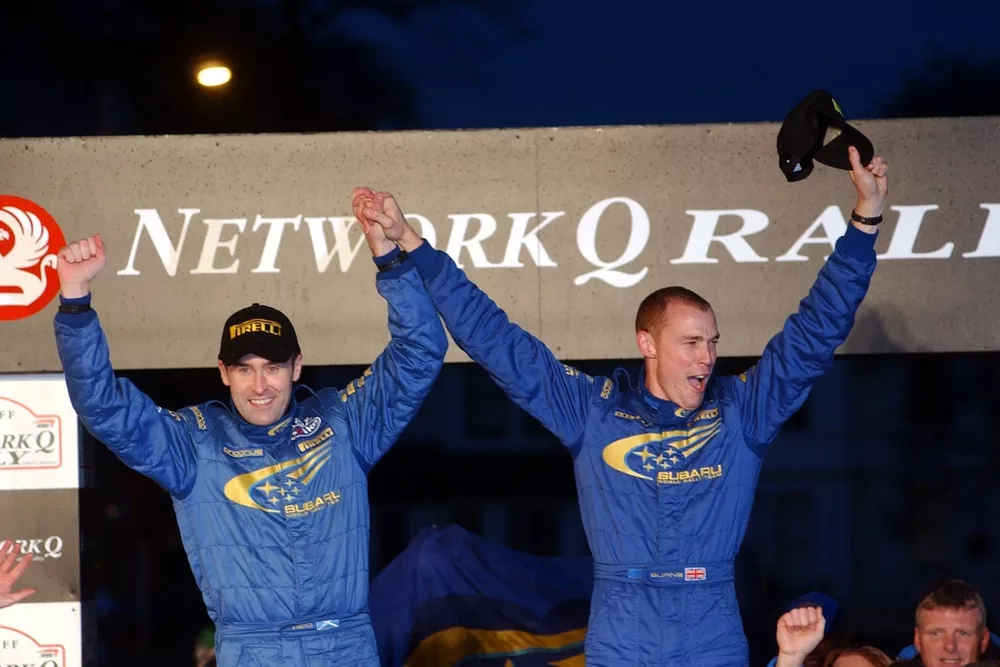 Richard Burns and Robert Reid celebrate on the podium