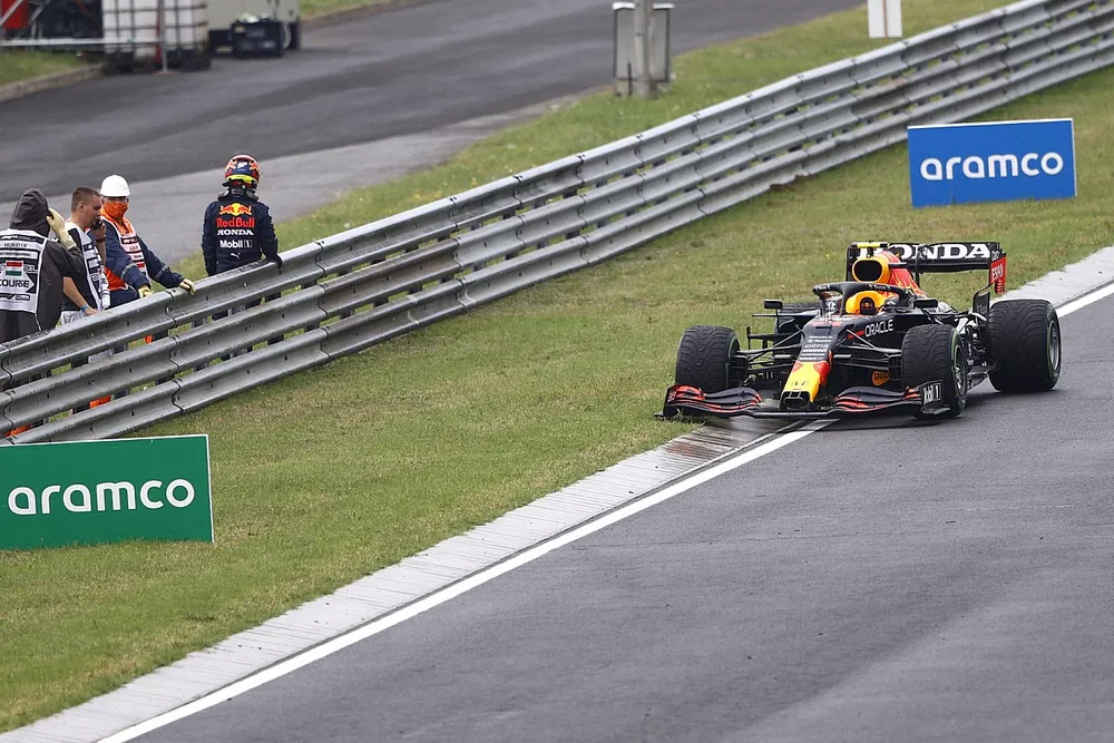 Sergio Perez, Red Bull Racing RB16B, abandons his damaged car as marshals assist