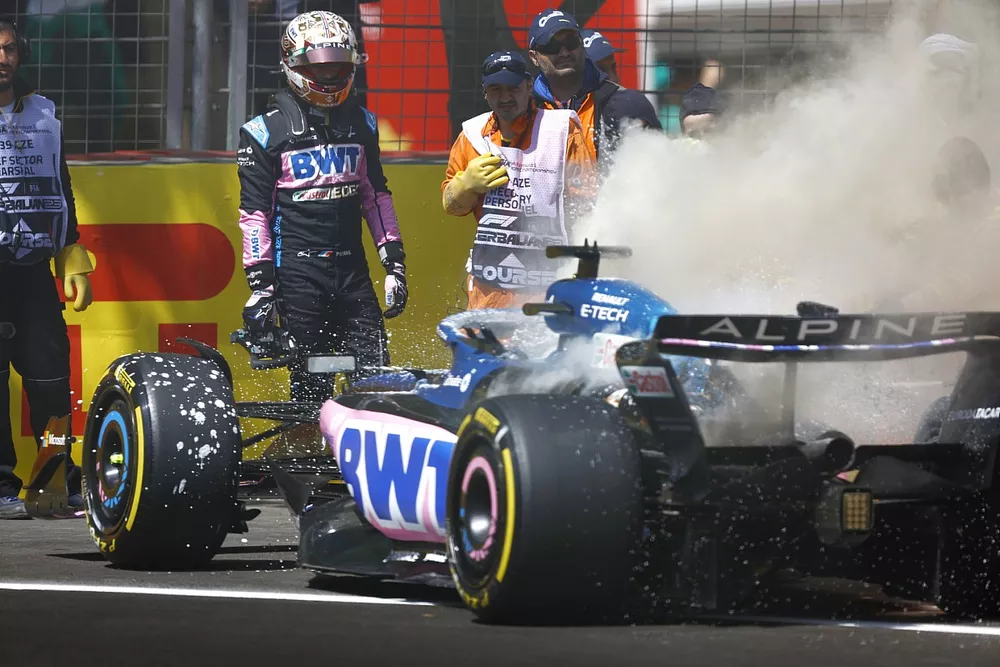 Pierre Gasly, Alpine A523, stand by as marshals assist with a fire