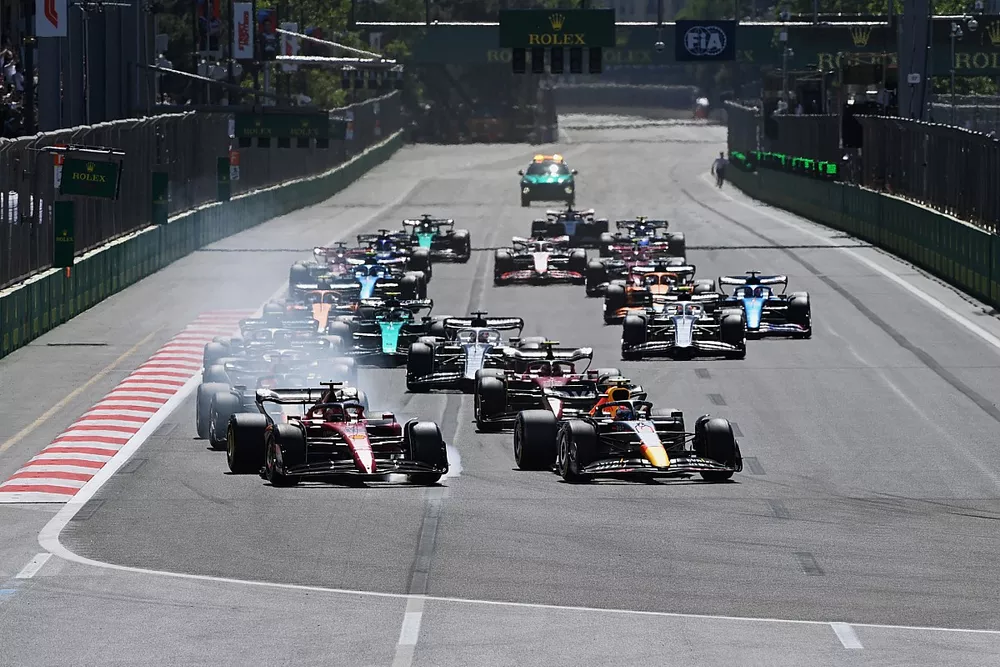 Charles Leclerc, Ferrari F1-75, Sergio Perez, Red Bull Racing RB18, battle for the lead ahead of Max Verstappen, Red Bull Racing RB18, Carlos Sainz, Ferrari F1-75, the rest of the field at the start