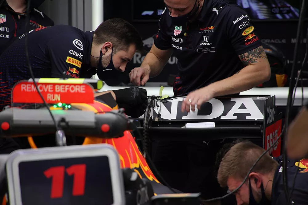 Red Bull Racing team members at work on the rear wing