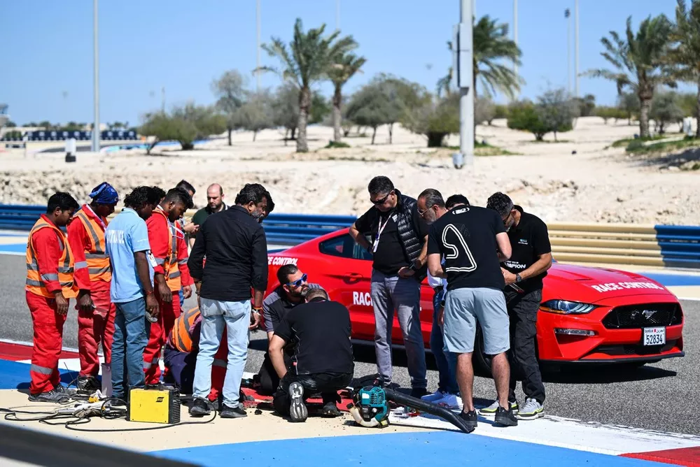Marshalls and race control work to fix a loose drain cover