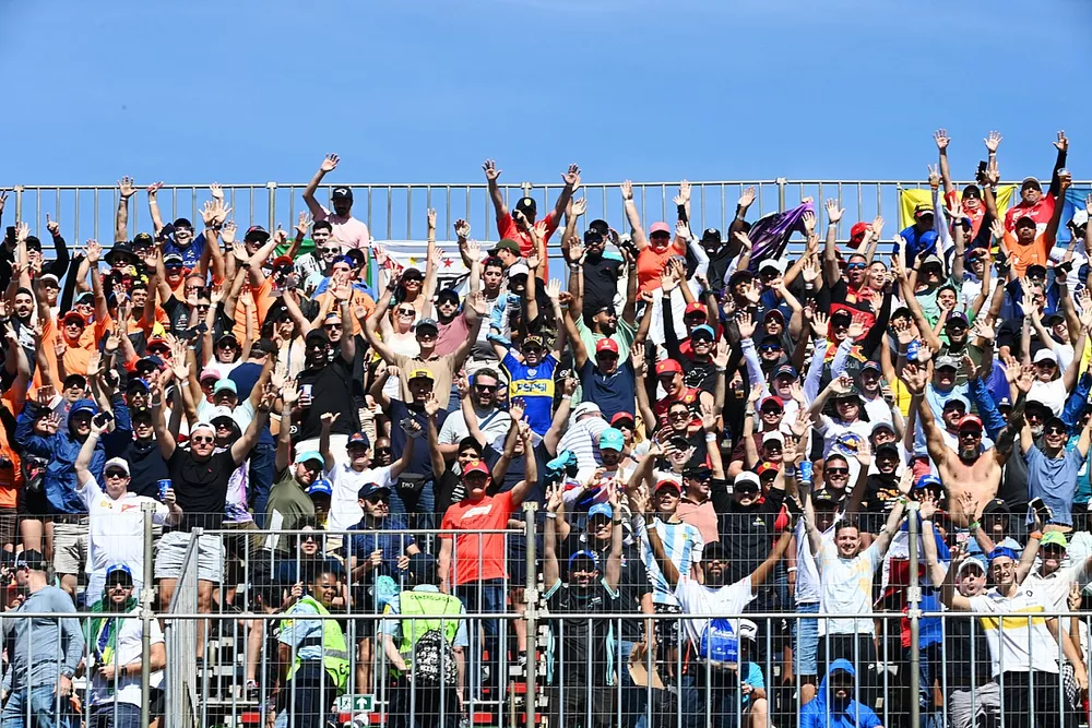 Fans wave from a grandstand