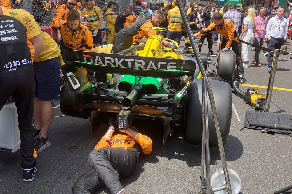 Mechanics working on floor of the McLaren MCL38