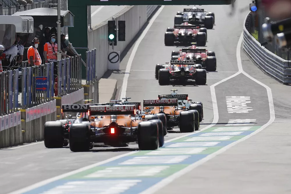 Sergio P&eacute;rez, Red Bull Racing RB16B , Daniel Ricciardo, McLaren MCL35M en pit lane