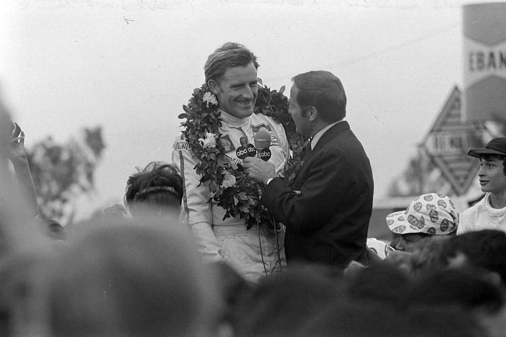 Graham Hill, en primera posici&oacute;n, es entrevistado en el podio.