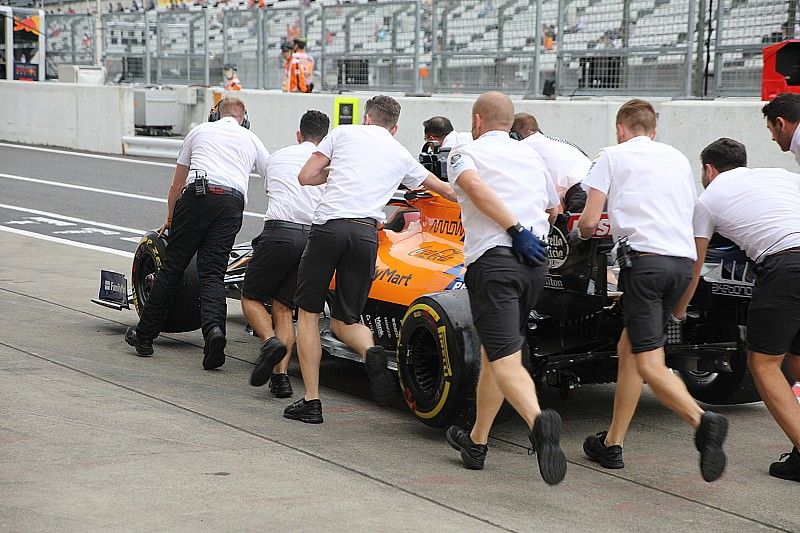 McLaren MCL34 siendo empujado por miembros del equipo