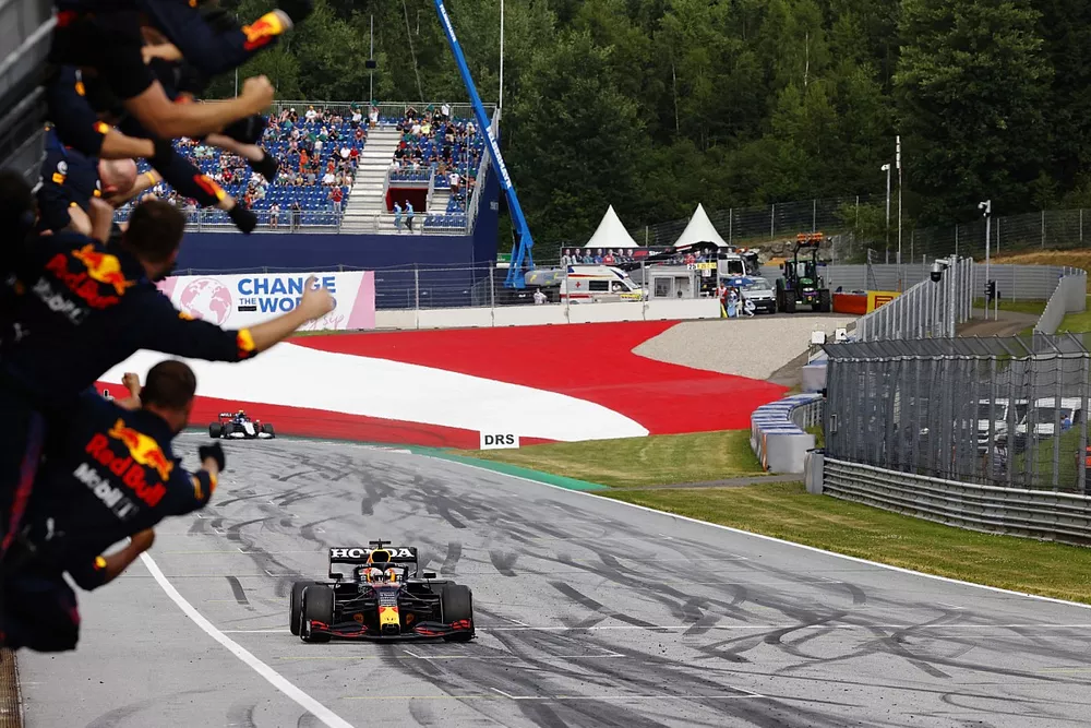Max Verstappen, Red Bull Racing RB16B, 1st position, is cheered over the line by his team on the pit wall