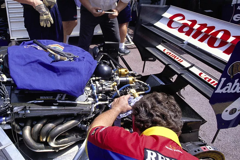 Mechanics work on a Williams FW14B Renault in the pits