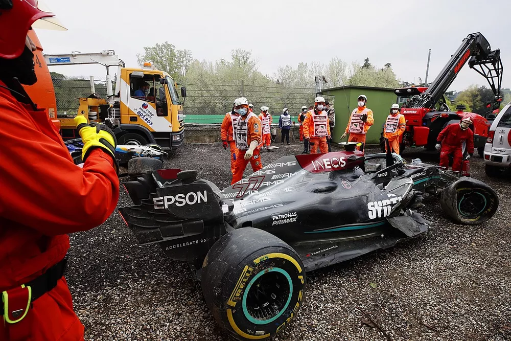 Marshals clear the damaged car of Valtteri Bottas, Mercedes W12, from the gravel trap
