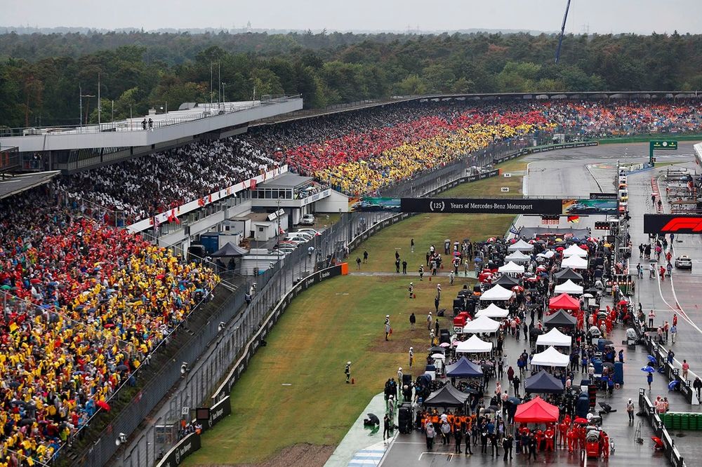 Todos los coches en la parrilla con fans con la bandera alemana