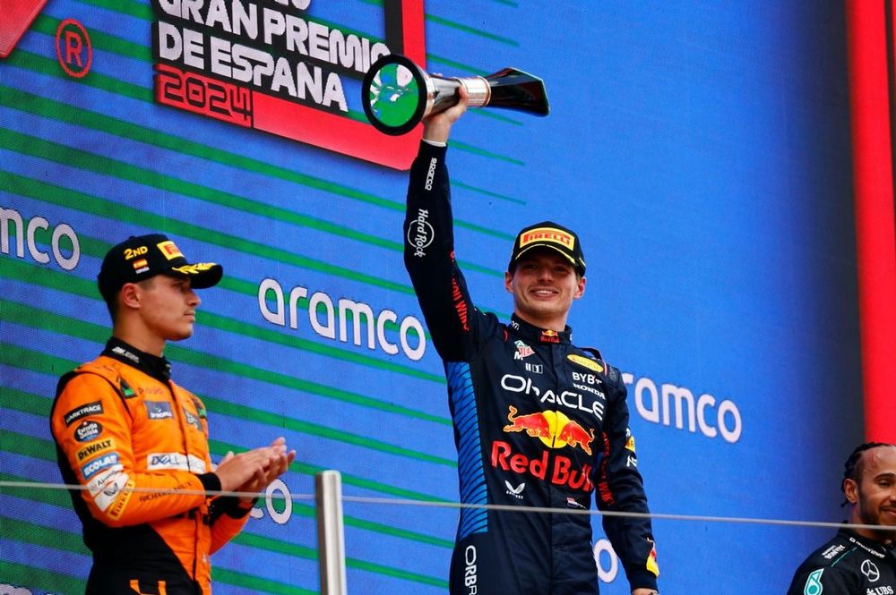 Max Verstappen, Red Bull Racing, 1st position, lifts the winners trophy on the podium alongside Lando Norris, McLaren F1 Team, 2nd position