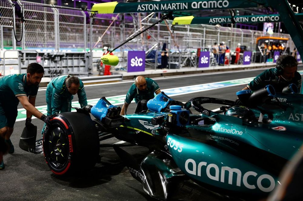 Mec&aacute;nicos del equipo Aston Martin F1 empujan el coche de Lance Stroll, Aston Martin AMR24 de vuelta al garaje.
