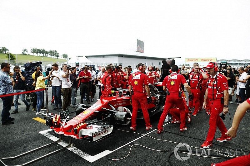 Equipo Ferrari fren&eacute;ticamente intenta arreglar el SF70H de Ferrari de Kimi Raikkonen en la red, el periodista Jonathan Noble mira