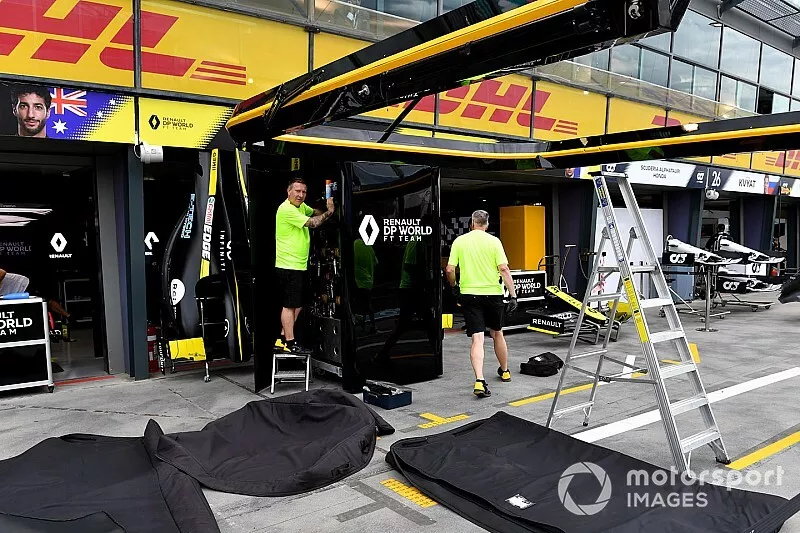 Renault personnel pack away their equipment in the pits