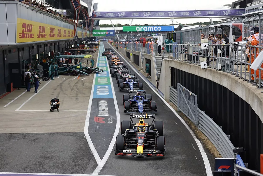Sergio Perez, Red Bull Racing RB19, Alex Albon, Williams FW45, Logan Sargeant, Williams FW45, others in the queue to leave the pits