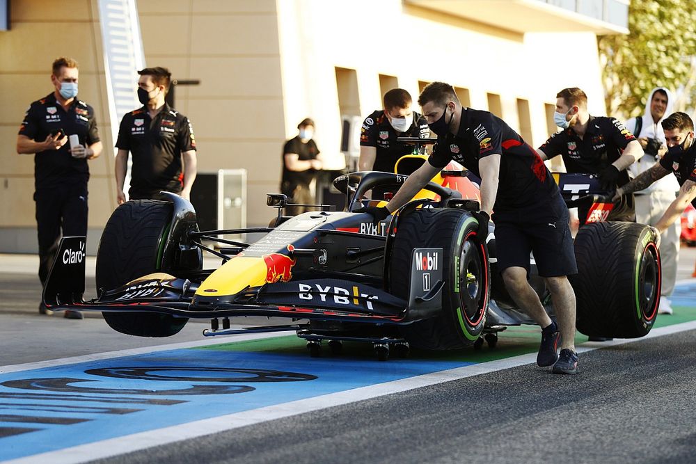 Los mecánicos empujan el coche de Max Verstappen, Red Bull Racing RB18, por el pitlane