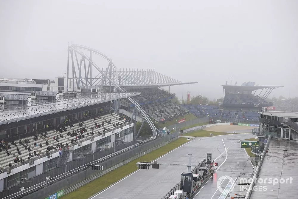 Fans sit in the grandstands as rain falls