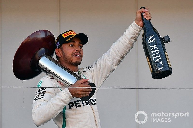 Il vincitore della gara Lewis Hamilton, Mercedes AMG F1, festeggia sul podio con il trofeo e lo champagne