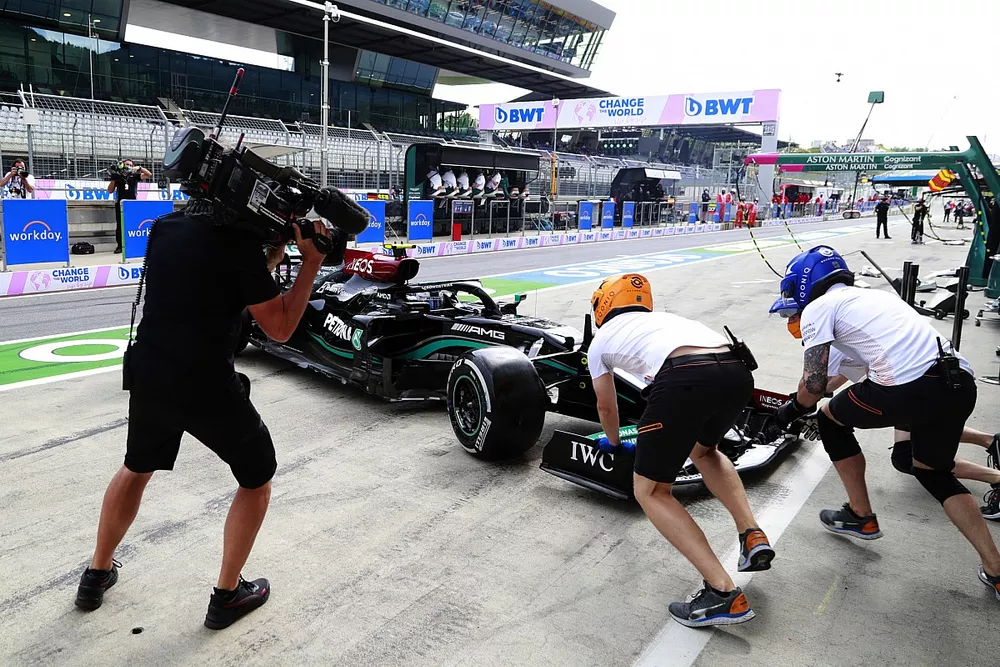 Des membres de McLaren assistent Valtteri Bottas, Mercedes W12, dans la voie des stands