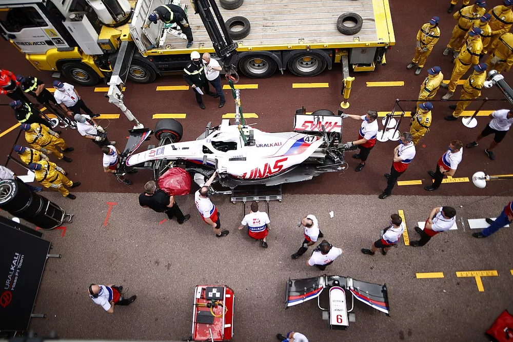 Los mec&aacute;nicos, con el coche accidentado de Mick Schumacher, Haas VF-21