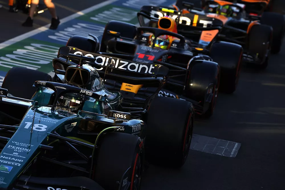 Lance Stroll, Aston Martin AMR23, Sergio Perez, Red Bull Racing RB19, and Lando Norris, McLaren MCL60, in the pit lane