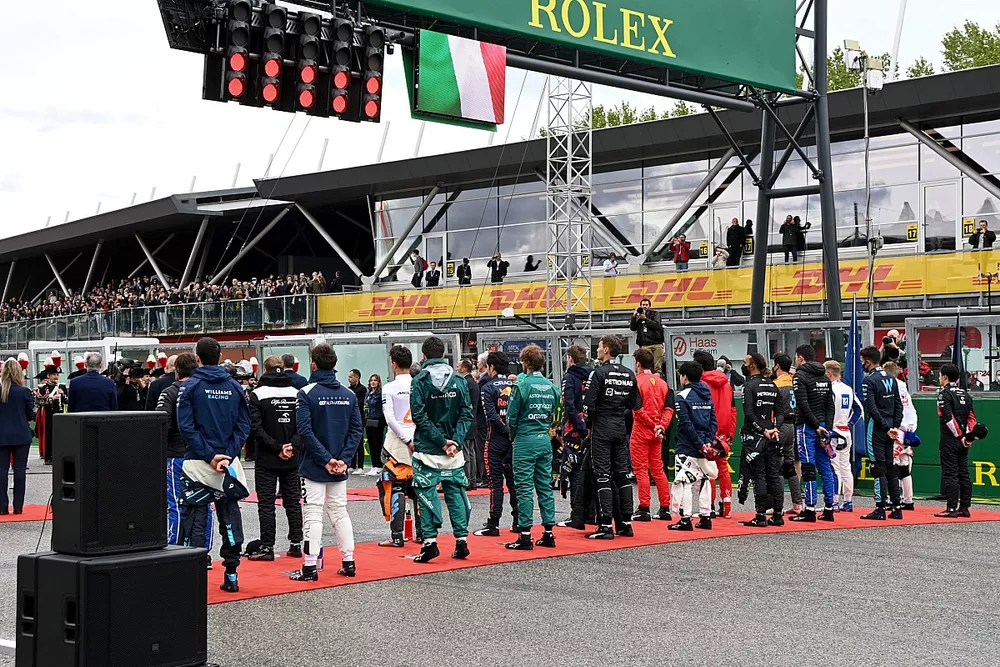 I piloti in piedi sulla griglia per l'inno nazionale prima della partenza
