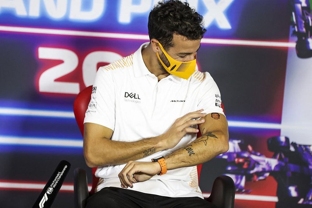 Daniel Ricciardo, McLaren, points to a temporary tattoo of Fernando Alonso, Alpine F1