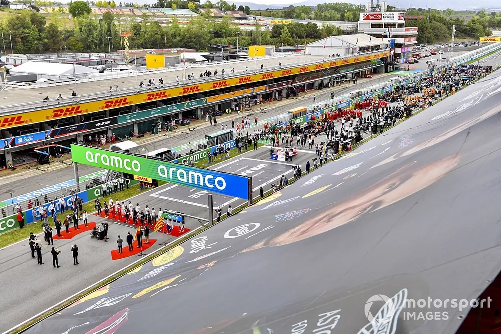 Los pilotos se ponen en fila en la parrilla para el himno nacional antes de la salida