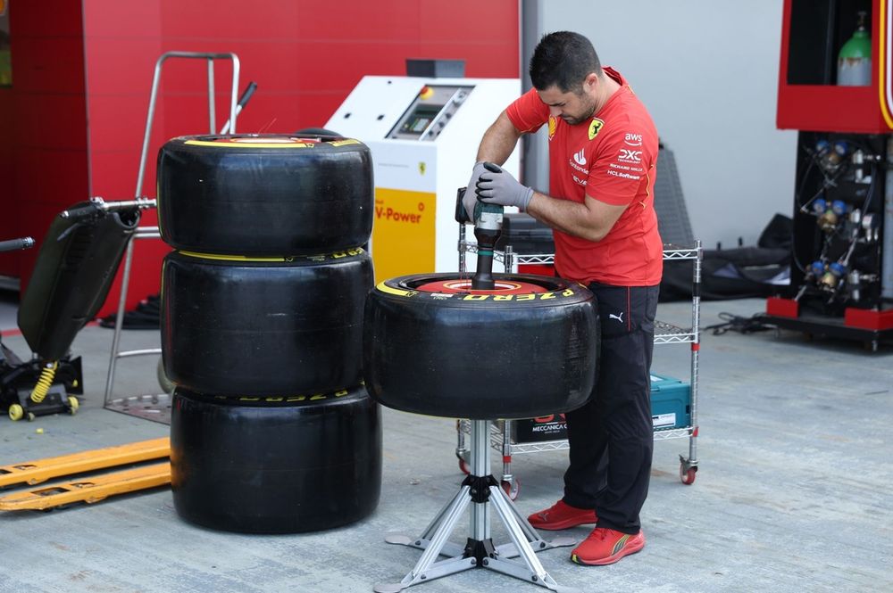 A Scuderia Ferrari mechanic works on Pirelli tyres