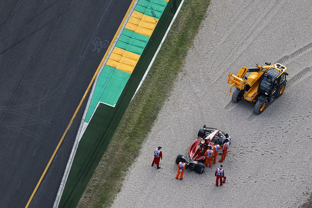 Marshals assist Carlos Sainz Jr., Ferrari F1-75, after a beaching in a gravel trap