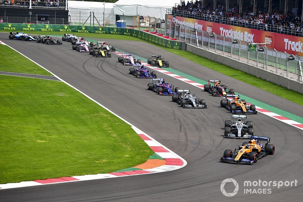 Carlos Sainz Jr., McLaren MCL34, leads Lewis Hamilton, Mercedes AMG F1 W10, Lando Norris, McLaren MCL34, Valtteri Bottas, Mercedes AMG W10, Max Verstappen, Red Bull Racing RB15, Daniil Kvyat, Toro Rosso STR14, and the remainder of the field on the opening lap