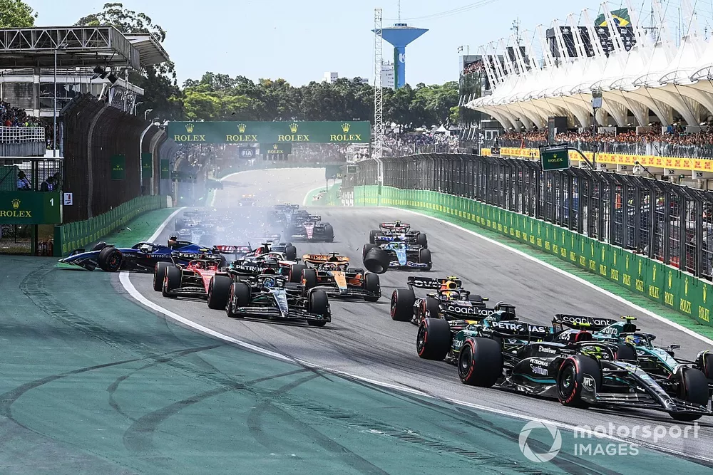 Sir Lewis Hamilton, Mercedes F1 W14, leads Fernando Alonso, Aston Martin AMR23, Lance Stroll, Aston Martin AMR23, and the rest of the field as a crash unfolds between Kevin Magnussen, Haas VF-23, and Alex Albon, Williams FW45
