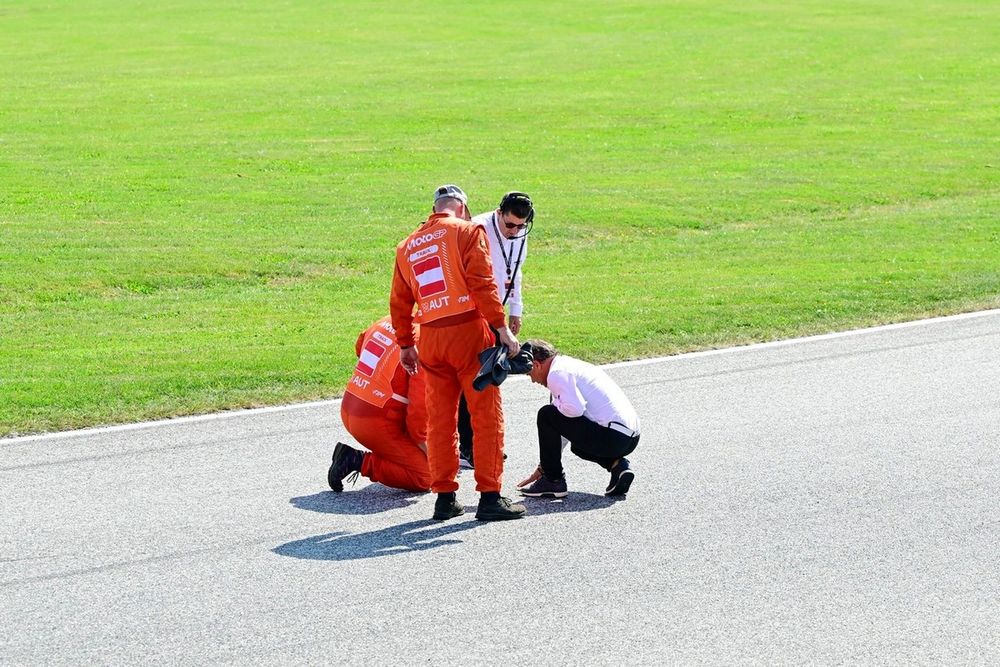 The marshals check the track after a red flag.
