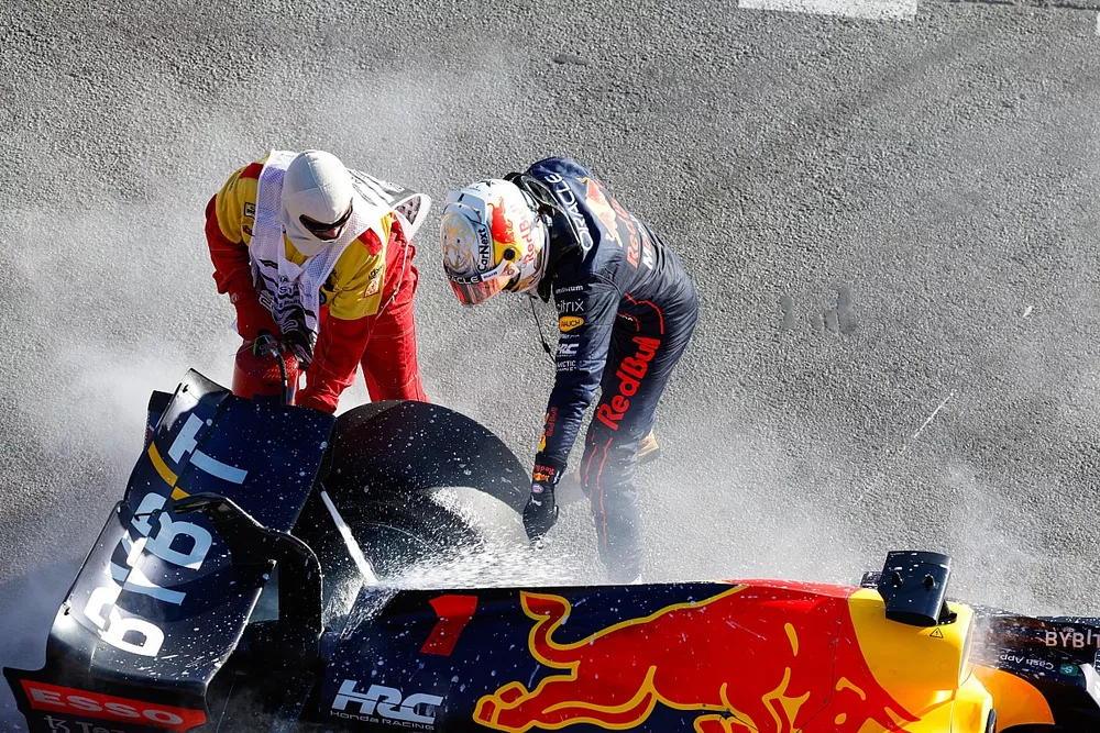 Max Verstappen, de Red Bull Racing, se retira de la carrera y un comisario asiste un incendio
